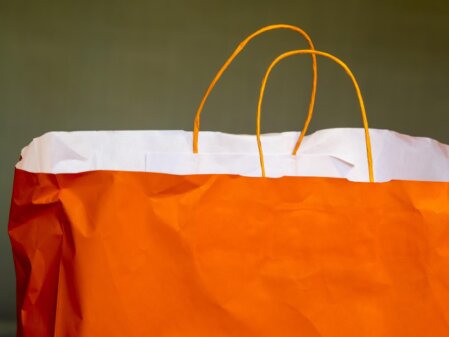 Volunteer in the charity shop helping a customer choose an item